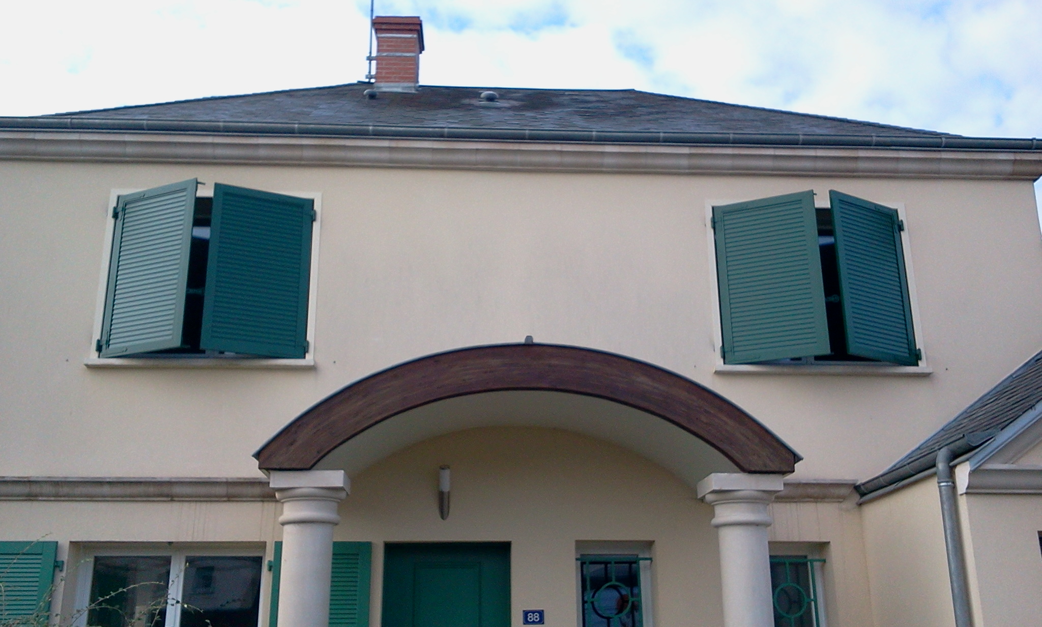 vue global d'une maison avec volet vert